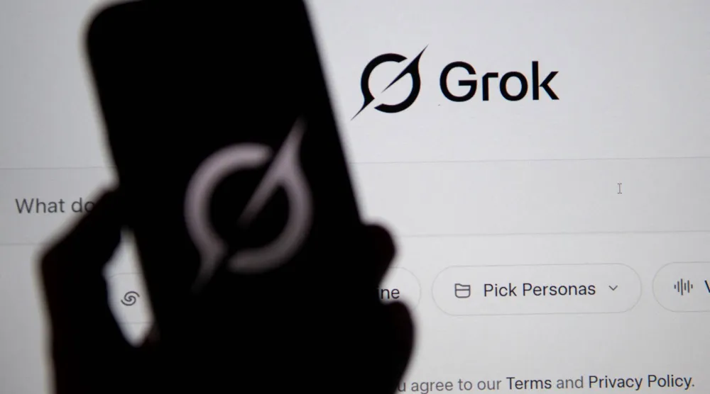 شعار روبوت الدردشة «غروك» يظهر على شاشتين (أ.ف.ب)