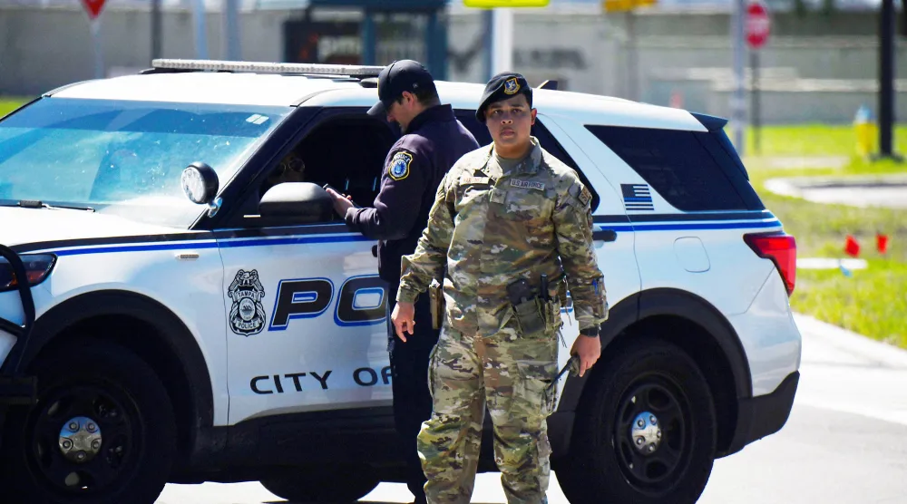 شرطي أميركي وأحد عناصر القوات الجوية بدورية بعد العثور على جسم مشبوه قرب قاعدة ماكديل في تامبا بولاية فلوريدا الأميركية 18 مارس 2026 (رويترز)