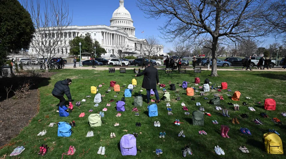نُصب تذكاري من أحذية وحقائب ترمز إلى ضحايا تفجير مدرسة ميناب الابتدائية في إيران... أمام مبنى الكابيتول الأميركي في العاصمة واشنطن في 18 مارس 2026 (أ.ف.ب)