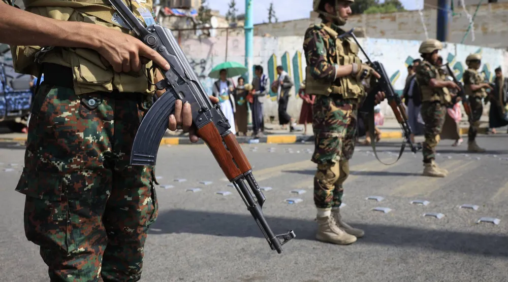 عناصر حوثيون بأحد شوارع صنعاء يحملون رشاشات خفيفة (إ.ب.أ)