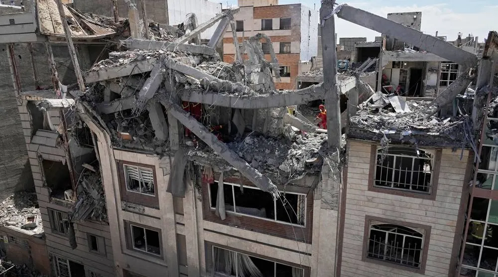  First responders inspect a residential building hit in an earlier US-Israeli strike in Tehran, Friday, March 27, 2026. (AP) 