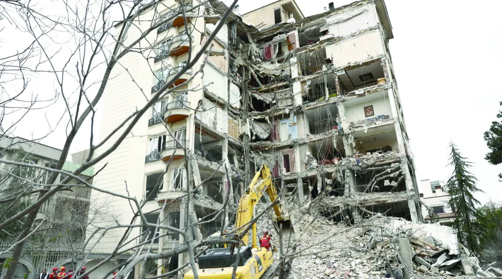 
عمال إنقاذ يعملون على إزالة ركام مبنى دمر بغارة إسرائيلية على طهران (رويترز)