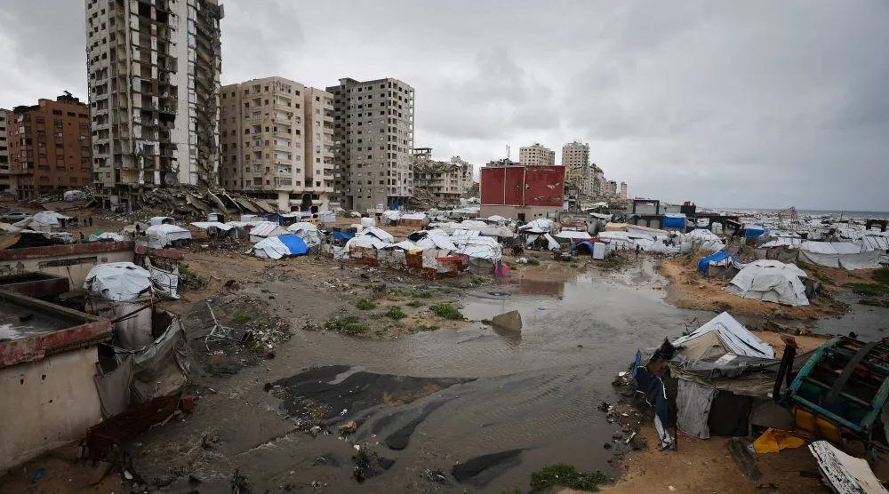 لاجئون فلسطينيون يحتمون في مخيم بمدينة غزة في يوم ممطر... 26 مارس 2026 (رويترز)