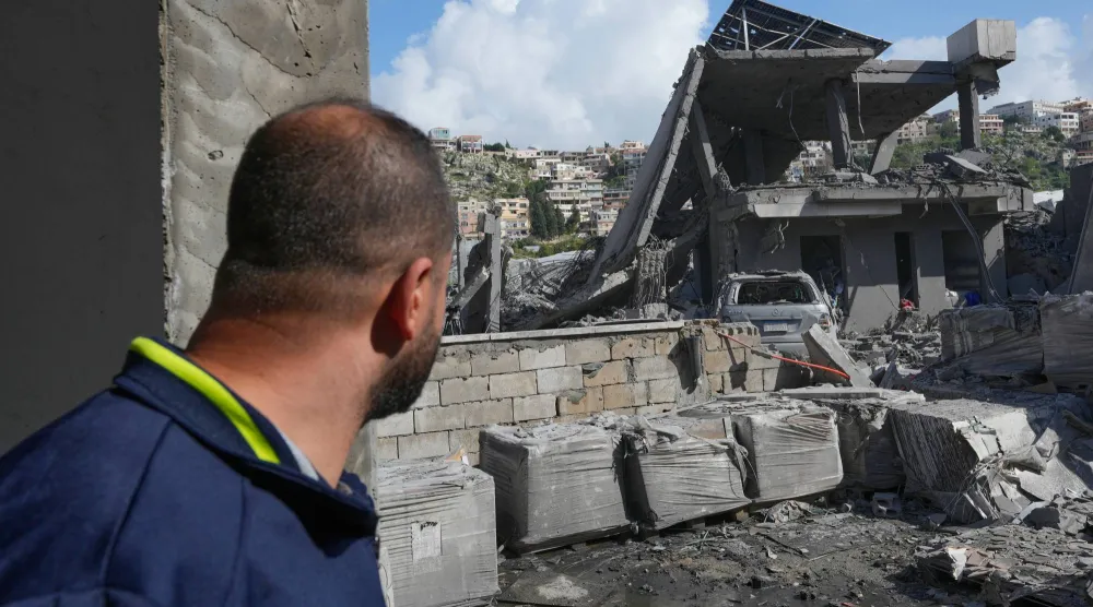 لبناني يشاهد دماراً لحق بأحد المنازل في السكسكية بجنوب لبنان (أ.ب)