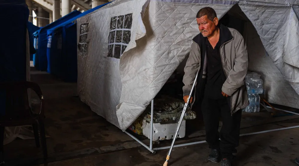 نازح لبناني خارج خيمة في مدينة كميل شمعون الرياضية في بيروت (أ.ف.ب)