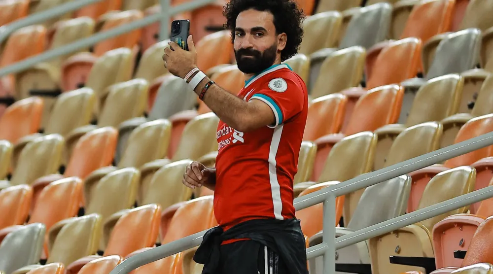 المشجع المصري شبيه النجم محمد صلاح يوثّق الحدث بهاتفه (رويترز)