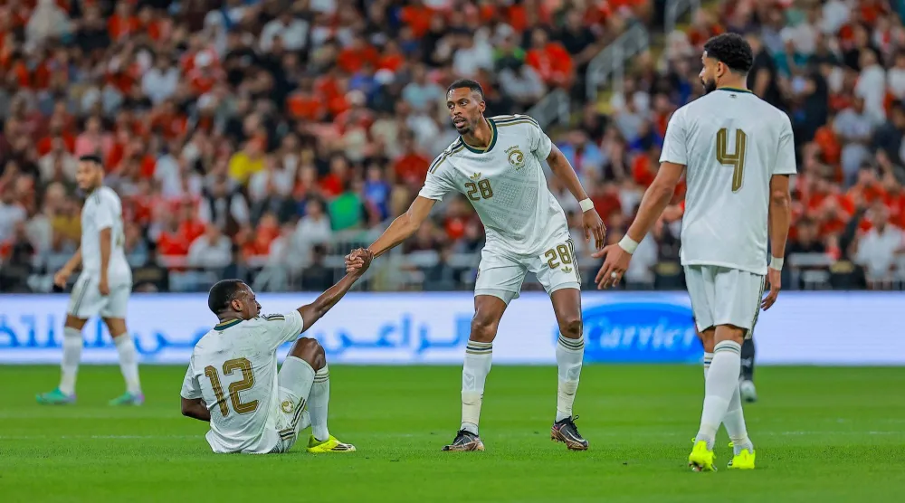 سعود عبد الحميد يتلقى مساعدة من زميله محمد كنو لحظة سقوطه على أرض الملعب خلال المباراة (تصوير: محمد المانع) 