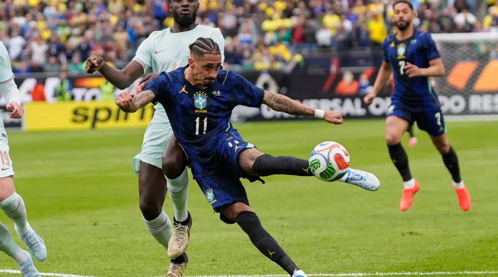 رافينيا يسدد الكرة تجاه المرمى الفرنسي (أ.ب)