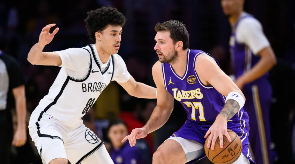 لوكا دونتشيتش «يمين» تألق في فوز ليكرز الكاسح على نتس (رويترز)