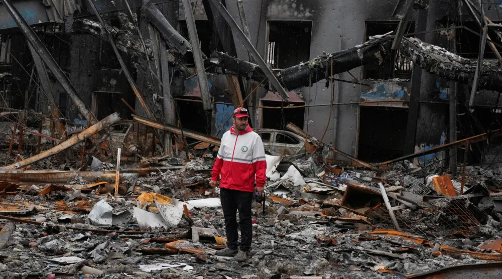 عنصر في «الهلال الأحمر الإيراني» اليوم السبت أمام ركام مبنى شركة تعرض للقصف في طهران يوم 1 مارس 2026 (أ.ب)