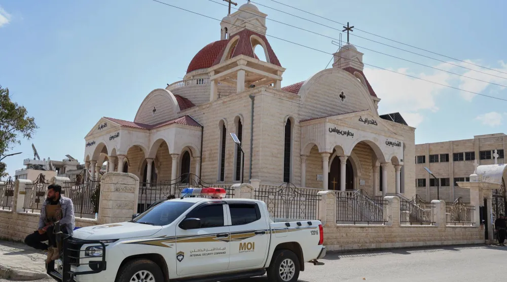 سيارة لقوات الأمن أمام كنيسة في السقيلبية اليوم السبت (أ.ب)