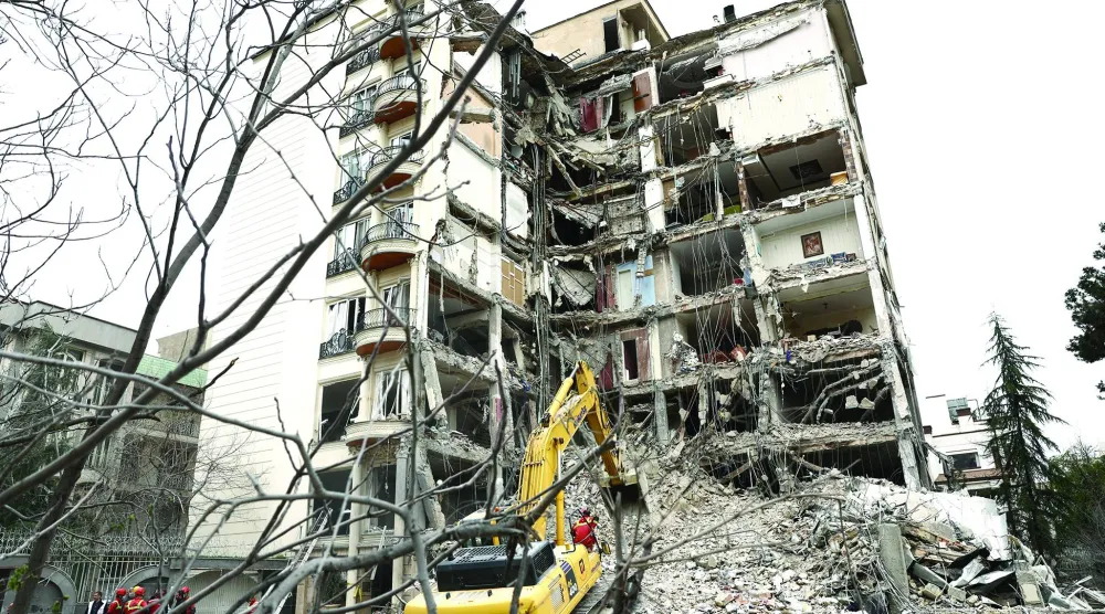 عمال إنقاذ يعملون على إزالة ركام مبنى دُمّر بغارة إسرائيلية على طهران (رويترز)