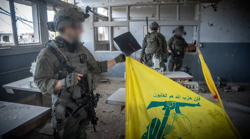 جندي إسرائيلي من وحدة «شيطيت 13» يمسك بعلم عليه شعار «حزب الله» خلال العمليات العسكرية في جنوب لبنان الجيش الإسرائيلي)