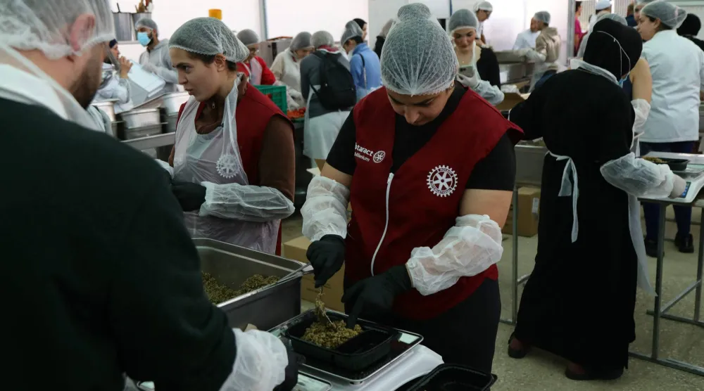 متطوعون في مطبخ خيري في بيروت يحضِّرون وجبات جاهزة للعائلات النازحة من الحرب (أ.ف.ب)