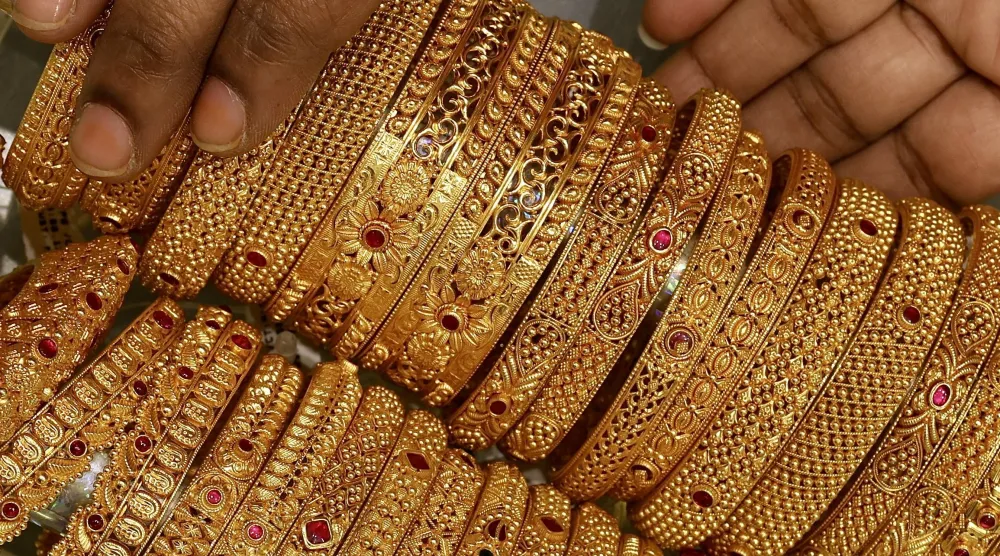 امرأة هندية تعرض قطعة مجوهرات ذهبية في متجر مجوهرات في بنغالور (أ.ف.ب)