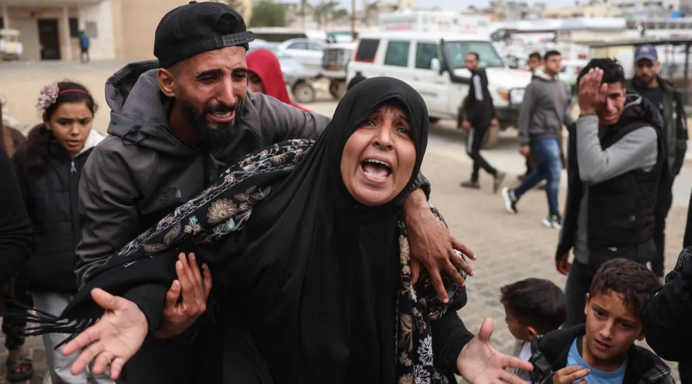 فلسطينيون يبكون أحد أحبائهم الذي قُتل في غارة جوية إسرائيلية على قطاع غزة (أ.ف.ب)