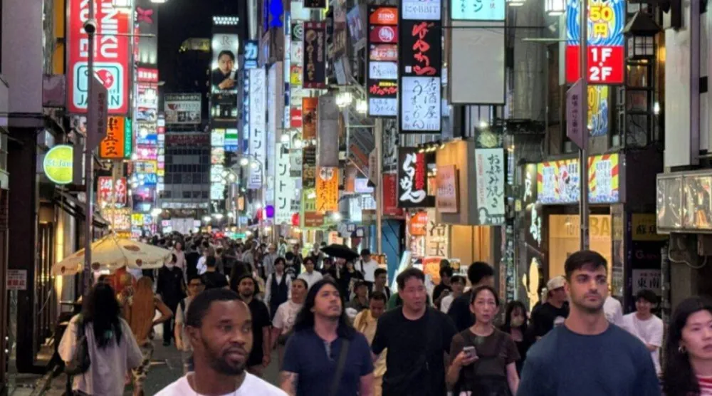 أشخاص يتجولون بمنطقة تسوق في طوكيو (رويترز)