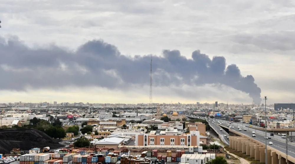 تصاعد الدخان من منطقة مطار الكويت الدولي بعد غارة جوية بطائرة مُسيرة استهدفت مستودع وقود (أ.ب)