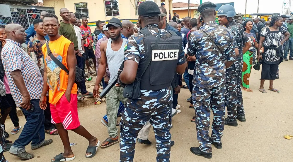 رجال شرطة ومواطنون في مكان الهجوم المسلح بجوس عاصمة ولاية بلاتو النيجيرية الاثنين (رويترز)