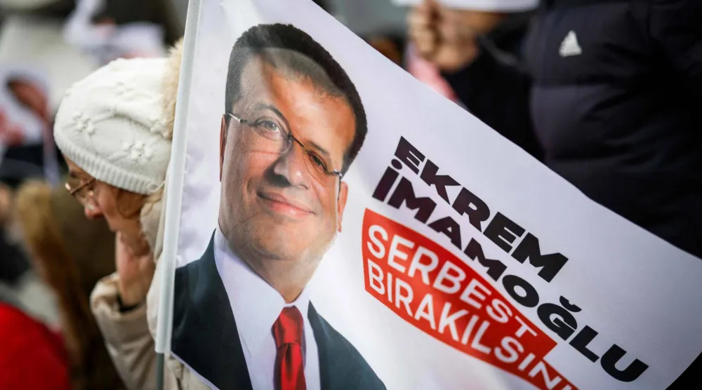 متظاهرون يرفعون لافتات تطالب بإطلاق سراح رئيس بلدية إسطنبول المحتجز أكرم إمام أوغلو مع انطلاق محاكمته بتهمة الفساد في قاعة داخل سجن سيليفري (أ.ف.ب)