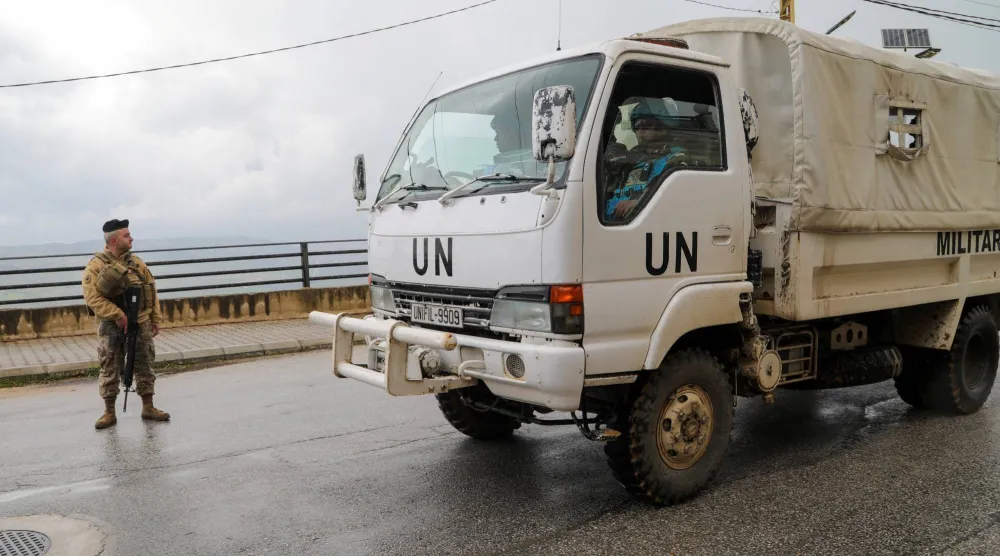 مركبة تابعة لقوات «يونيفيل» تمر بجانب جندي لبناني... جنوب لبنان 27 مارس 2026 (رويترز) 