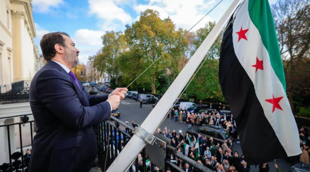 وزير الخارجية السوري أسعد الشيباني يرفع العلم السوري فوق مبنى السفارة في العاصمة البريطانية لندن أكتوبر 2025 (حساب الخارجية)