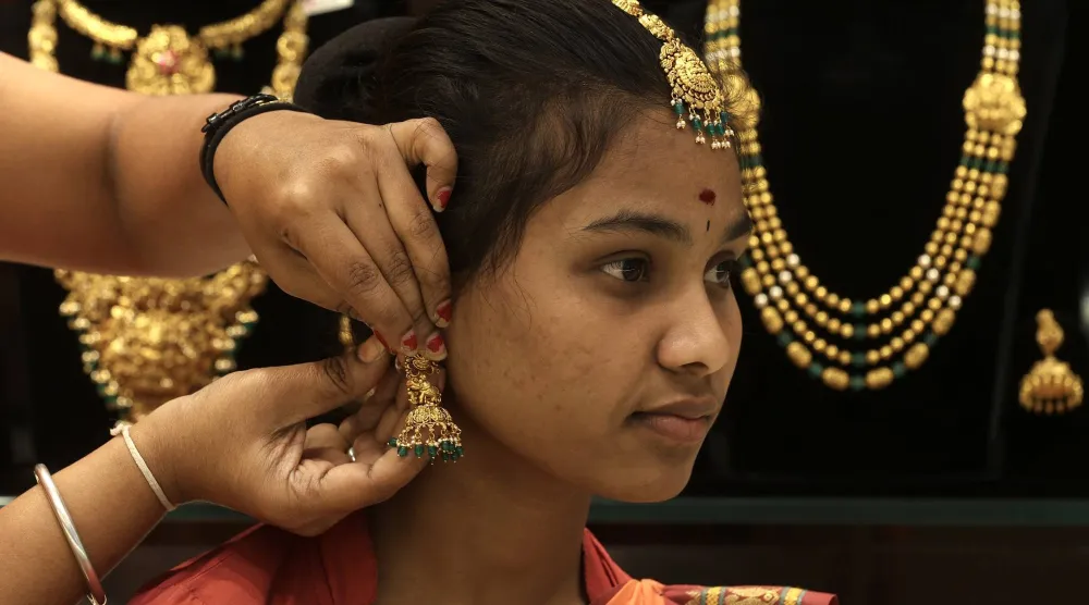 امرأة هندية تجرب حلياً ذهبية في متجر مجوهرات (إ.ب.أ)