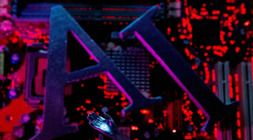 حروف الذكاء الاصطناعي ويد روبوت موضوعة على لوحة أم لجهاز كمبيوتر (رويترز)