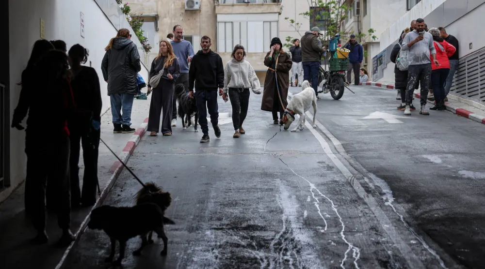 إسرائيليون يتوجهون نحو موقف سيارات تحت الأرض للاحتماء مع دوي صفارات الإنذار في تل أبيب (رويترز)