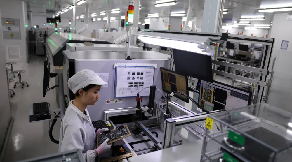 موظف يتفقد لوحة دوائر كهربائية في مصنع بمدينة شنتشن بمقاطعة قوانغدونغ الصينية (رويترز)