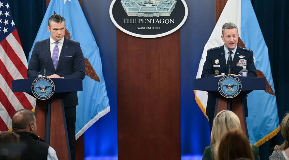 وزير الدفاع الأميركي بيت هيغسيث يستمع إلى رئيس هيئة الأركان المشتركة الجنرال دان كين خلال مؤتمر صحافي مشترك في البنتاغون (أ.ف.ب)