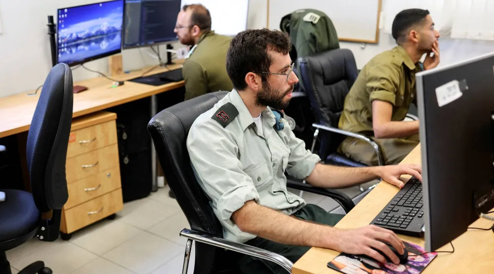 خبراء تكنولوجيا يعملون في وحدة بيانات وتطبيقات العمليات بالجيش الإسرائيلي (رويترز)