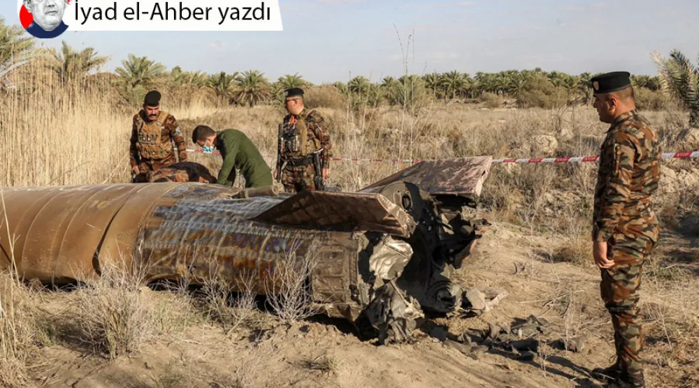 Irak İçişleri Bakanlığı bünyesindeki Patlayıcılarla Mücadele Müdürlüğü görevlileri, ülkenin orta kesimlerindeki Babil ilinin Hilla kenti yakınlarındaki Siyahe bölgesinde bir köye düşen roket yakıt tankını incelerken, 1 Mart 2026 (AFP)