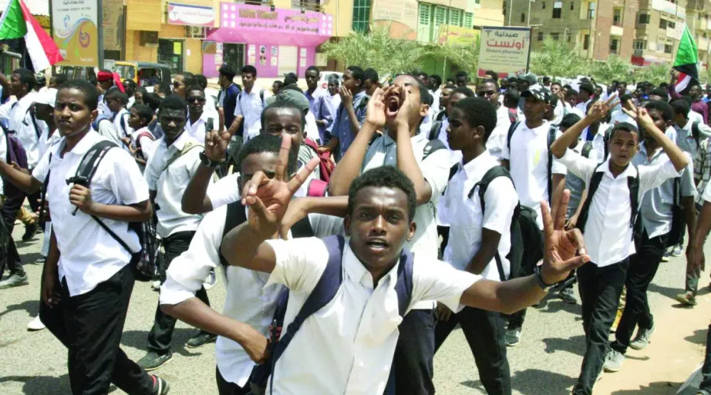 Hartum’da daha önce düzenlenen protestolar sırasında bir okulun öğrencileri (AFP)