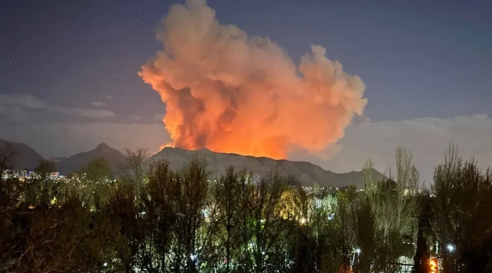 Dün sabaha karşı İran'ın orta kesimlerindeki İsfahan şehrinde bir mühimmat deposundan yükselen duman ve alevler (sosyal medya)