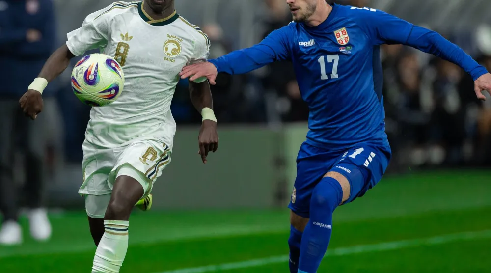 مروان الصحفي في صراع على الكرة مع لاعب منتخب صربيا (المنتخب السعودي) 