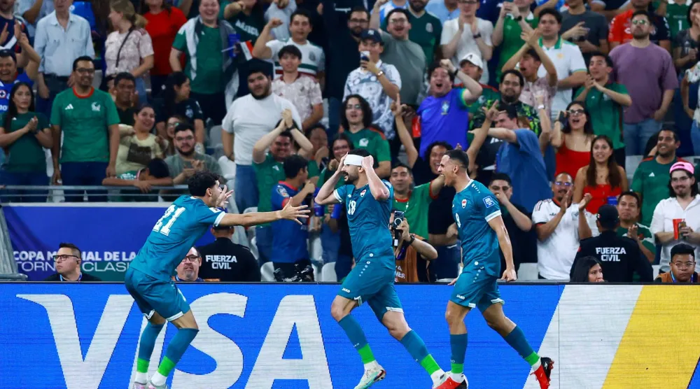 أيمن حسين يحتفل رفقة زملائه بالهدف الثاني (رويترز) 