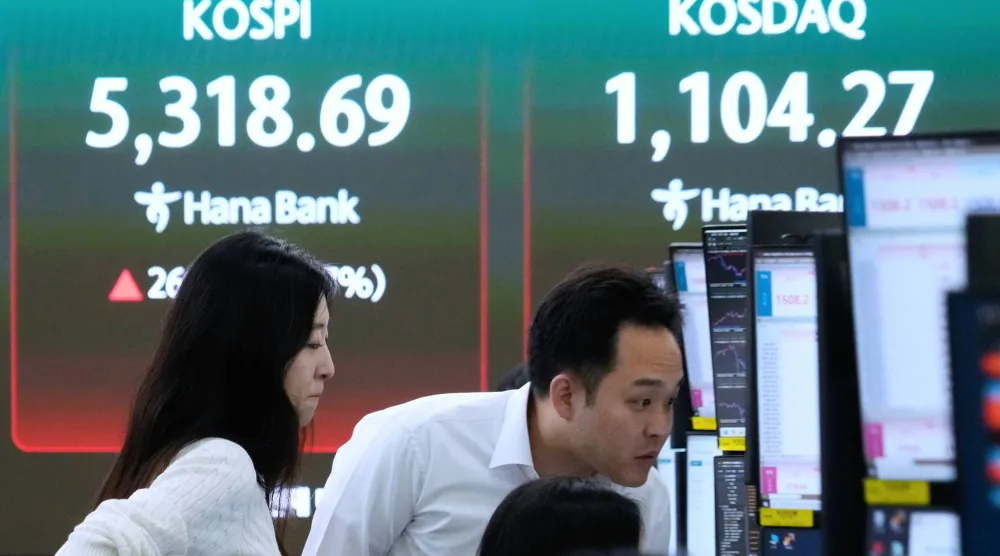 يراقب متداولو العملات شاشات بالقرب من شاشة تعرض مؤشر أسعار الأسهم الكوري المركب (كوسبي) في سيول (أ.ب)