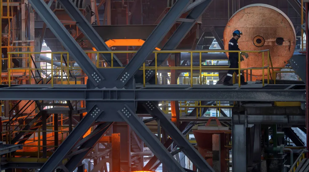 يمشي عامل فولاذ عبر فرن القوس الكهربائي في مصنع هاسليك ميلت قرب مدينة بيلجيك (رويترز)