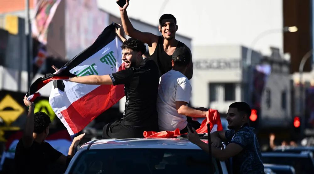 مواطنون عراقيون نزلوا للشارع احتفالاً بتأهل منتخب البلاد لـ«المونديال» (د.ب.أ)