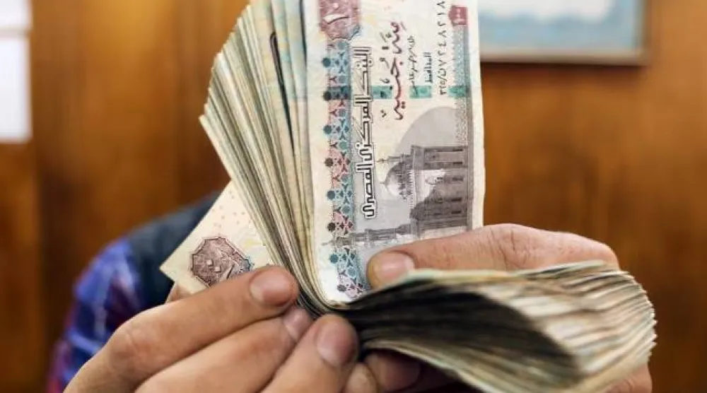 موظف يعد الجنيهات المصرية في مكتب صرافة وسط القاهرة (رويترز)