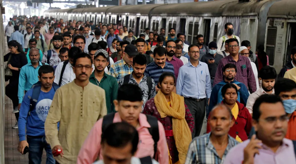 ركاب يسيرون على رصيف بمحطة قطار في مومباي بالهند (رويترز)