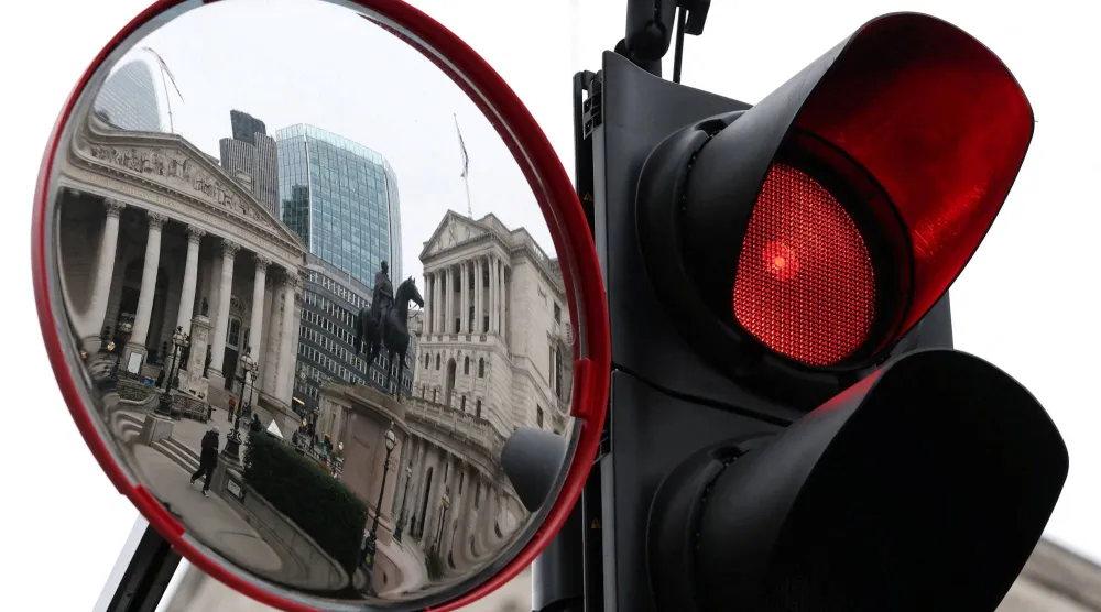 انعكاس مبنييْ بنك إنجلترا والبورصة الملكية في مرآة مرورية بلندن (رويترز)