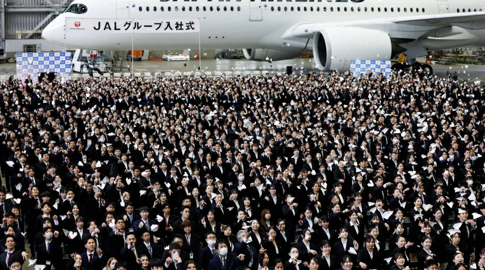 الموظفون الجدد في «شركة الخطوط الجوية اليابانية» يحتفلون ببداية عملهم داخل مقر الشركة بالعاصمة اليابانية طوكيو (رويترز)