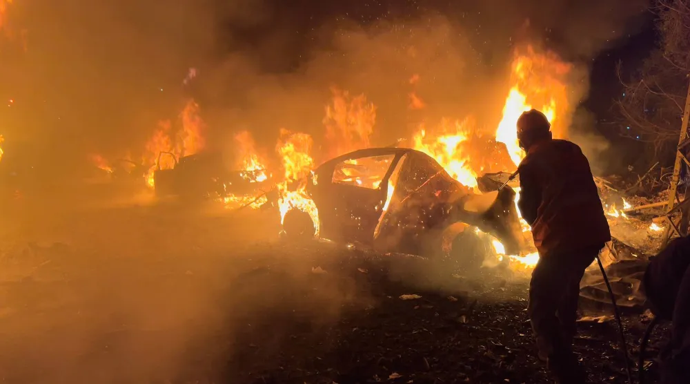 رجال إطفاء يشاركون في إخماد نيران اندلعت في سيارات استهدفتها إسرائيل في منطقة الجناح بمحيط بيروت فجر الأربعاء وأسفرت عن اغتيال القيادي بـ«حزب الله» يوسف هاشم (أ.ب)