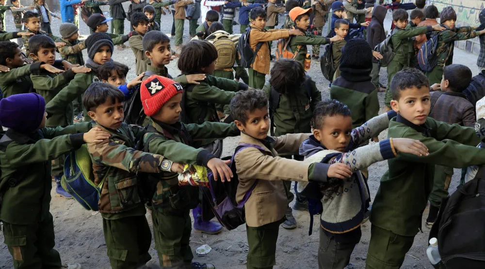 تلامذة يمنيون في الطابور الصباحي في إحدى مدارس صنعاء (غيتي) 