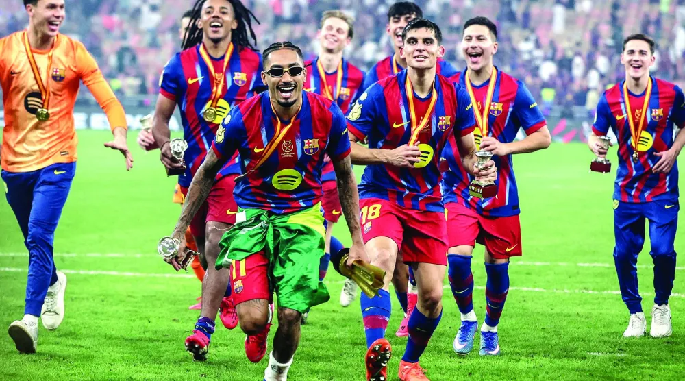 
رافينيا والفرحة بعد قيادته برشلونة للفوز على ريال مدريد وحصد لقب كأس السوبر الإسباني 2026 (أ.ف.ب)