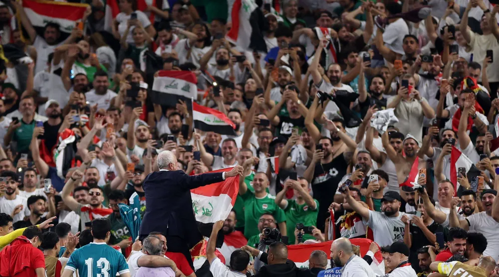 لاعبو العراق يحملون مدربهم على الأعناق بعد نهاية المباراة (أ.ف.ب)