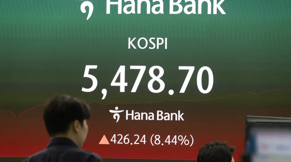 متداولون كوريون جنوبيون يعملون أمام شاشات في بنك هانا في سيول (إ.ب.أ)