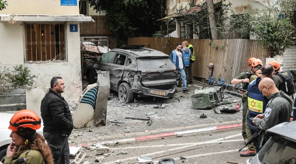 قوات الأمن الإسرائيلية وفرق الإنقاذ تعمل في موقع سقوط صاروخ في حي سكني بتل أبيب عقب هجوم إيراني أمس (أ.ف.ب)